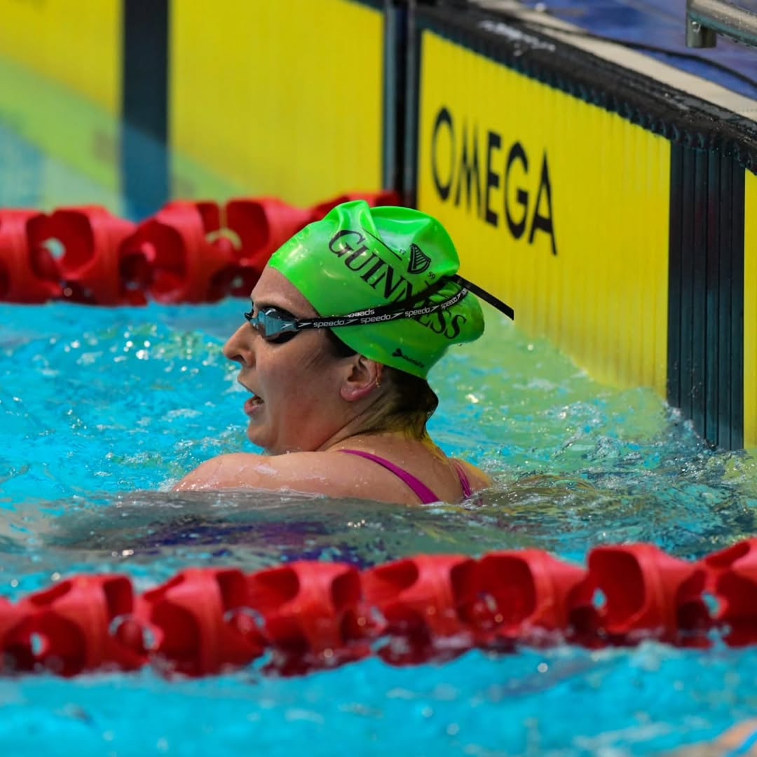 GSC swimmer in a green Guinness cap finishing a race at the Irish Masters Long Course Championships